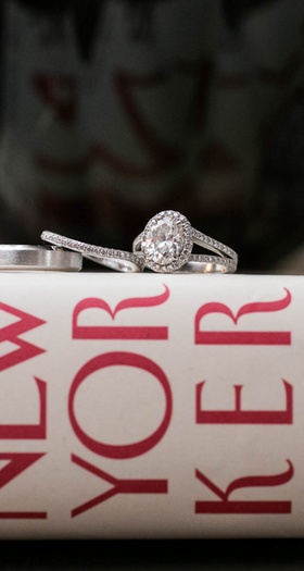 Oval-Cut Halo Ring on Book
Photography: Images by Berit, Inc.
Read More:
http://www.insideweddings.com/weddings/gatsby-inspired-jewish-wedding-with-purple-gold-decor-in-new-york/720/ The New Yorker book with wedding band, eternity band, and engagement ring on top
