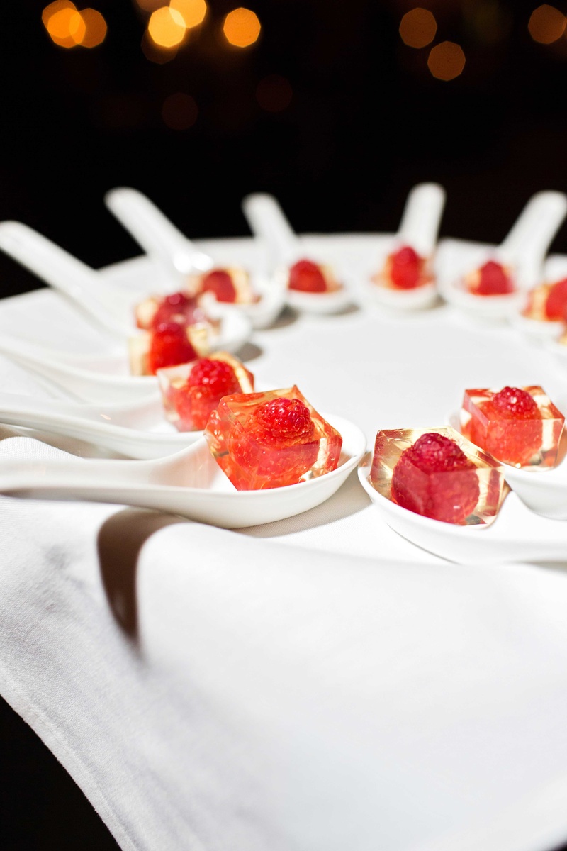 Jello Shots with Raspberries in Center
Photography: Perez Photography
Read More:
http://www.insideweddings.com/weddings/incredible-tented-ceremony-barn-reception-at-ranch-in-aspen/860/ White spoons on tray with raspberries in middle of clear jello squares for dessert