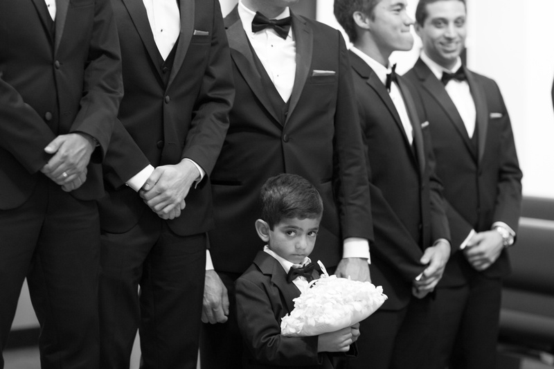 Shy Ring Bearer with Groomsmen
Photography: Jay Lawrence Goldman Photography
Read More:
http://www.insideweddings.com/weddings/elegant-white-lavender-ballroom-wedding-with-cherry-blossom-trees/710/ Black and white photo of young ring bearer in tux standing in front of groomsmen