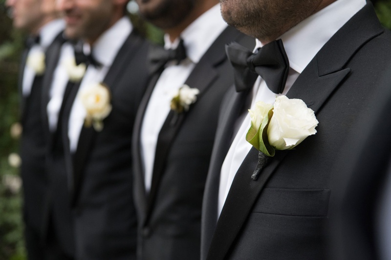 Ivory Rose Boutonnieres for Groomsmen
Photography: John Solano Photography
Read More:
http://www.insideweddings.com/weddings/an-opulent-garden-ceremony-ballroom-reception-in-beverly-hills/986/ Line of groomsmen in tuxedos wearing matching bow ties and flower boutonniere rose style