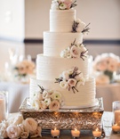 Four-Layer Cake with Fresh Flower Clusters
Photography: Laurie Bailey Photography
Read More:
http://www.insideweddings.com/weddings/church-ceremony-elegant-reception-in-the-pacific-palisades/1142/ White wedding cake ribbed frosting buttercream with clusters of fresh ranunculus rose purple foliage