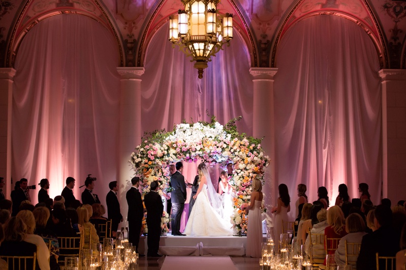 Floral Chuppah in Italian-Style Ballroom
Photography: Muñoz Photography
Read More:
http://www.insideweddings.com/weddings/colorful-jewish-ceremony-ballroom-reception-at-the-breakers/818/ Bride and groom at The Breakers wedding ceremony flower arch chuppah Jewish wedding pink lighting