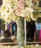 Pastel Arrangement in Unique Vase
Photography: Karlisch Studio
Read More:
http://www.insideweddings.com/weddings/southern-chic-wedding-in-oklahoma-with-performance-by-boyz-ii-men/697/ Wedding escort card table covered in flowers, vase covered in leaves with pink roses, white peonies