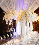 Floral Arrangement with Alabaster Vases
Photography: Brian Leahy Photography
Read More:
http://www.insideweddings.com/weddings/beachy-southern-california-ceremony-winter-wonderland-reception/877/ ghost chairs, silver sequin linens, white vases, orchid and rose centerpieces
