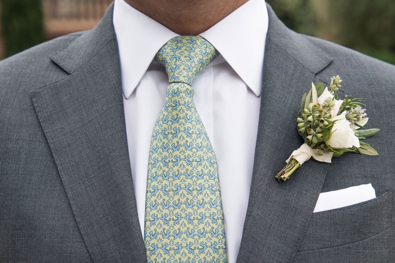 Natural Bouquet with Matching Tie
Photography: Triple Cord Photography
Read More:
http://www.insideweddings.com/weddings/destination-wedding-with-outdoor-reception-lavish-after-party/982/ Groom with patterned tie yellow blue green with natural bouquet tied with ribbon greenery white rose