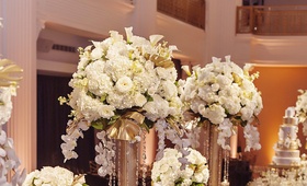 Lush Florals with Gold and Crystal Details
Photography: Kortnee Kate Photography
Read More:
http://www.insideweddings.com/weddings/glitzy-glamorous-wedding-with-black-gold-palette-in-cincinnati/1056/ ivory flowers on gold stand with crystals, gold painted split leaves