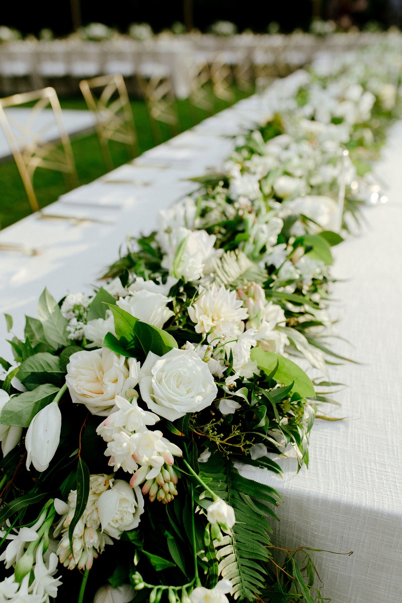 Greenery %26 Floral Runner with Gold Chairs
Photography: Chris J. Evans Photography
Read More:
http://www.insideweddings.com/weddings/outdoor-winter-ceremony-and-reception-on-the-big-island-in-hawaii/1306/ wedding reception white linen tablecloth with flower runner greenery fern tropical plants white rose