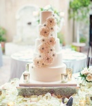 Sugar Flower Five-Layer Cake
Photography: Trevor Dayley
Read More:
http://www.insideweddings.com/weddings/spring-wedding-at-tuscan-inspired-golf-club-in-scottsdale-arizona/814/ Wedding cake surrounded by white flower petals and sugar flower decorations mercury glass candles