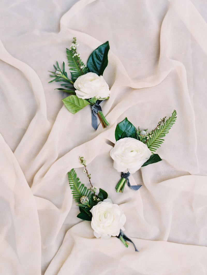 White Floral Boutonniere with Blue Ribbon
Photography: Mallory Dawn Photography
Read More:
http://www.insideweddings.com/weddings/outdoor-jewish-ceremony-luxe-reception-at-vibiana-in-downtown-la/1259/ white ranunculus boutonniere with green leaves and ferns blue ribbon