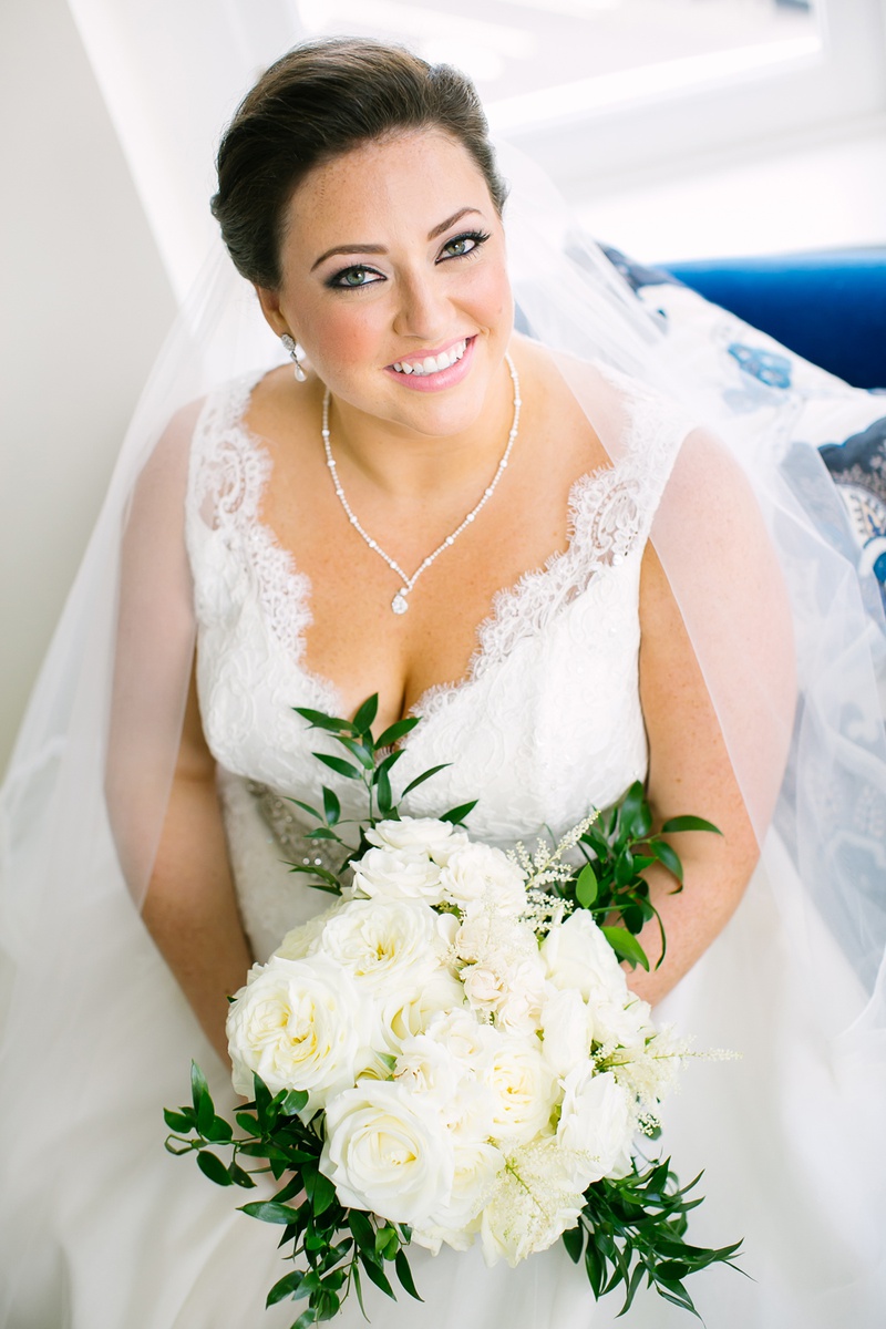 Soft Makeup with Pink Lip for Bride
Photography: K. Thompson Photography
Read More:
http://www.insideweddings.com/weddings/traditional-ceremony-ballroom-reception-with-blue-gold-decor/1201/ bride in v neck wedding dress lace pretty necklace earrings white bouquet eyeliner pink lipstick