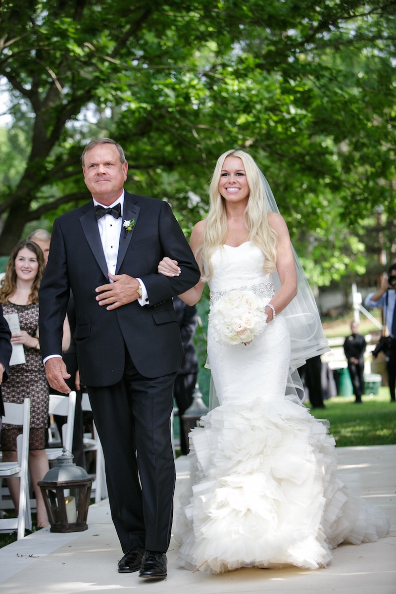 Bride Walks Down the Aisle with Father
Photography: Karlisch Studio
Read More:
http://www.insideweddings.com/weddings/southern-chic-wedding-in-oklahoma-with-performance-by-boyz-ii-men/697/ Bride in a fit-and-flare Vera Wang dress, sparkling sash, ruffled skirt, veil & father in black tux