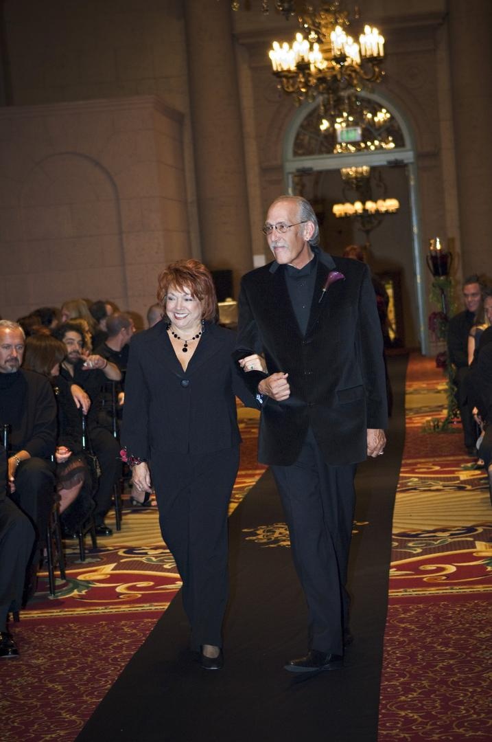 Loved Ones
Photography: Barnet Photography
Read More:
http://www.insideweddings.com/weddings/ashley-reeves-and-brandon-saller/261/ Lady in a black pant suit is escorted down the aisle by a gentleman in a black velvet blazer