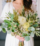Seasonal Bridal Bouquet
Photography: Wild Whim Design + Photography
Read More:
http://www.insideweddings.com/weddings/outdoor-bohemian-fall-wedding-at-a-magical-venue-in-los-angeles/1238/ bride in boho dress holding loose bouquet seasonal greenery with pale yellow ranunculus and dahlia