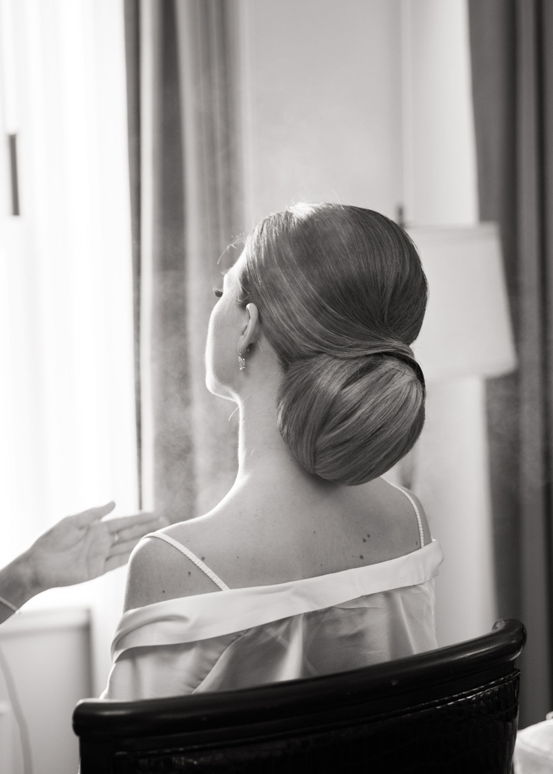 Bride's Elegant Coiffure
Photography: Ira Lippke Studios
Read More:
http://www.insideweddings.com/weddings/opulent-destination-wedding-at-a-luxury-hotel-in-new-york-city/1004/ black and white photo of bride getting ready wedding in robe off shoulder with updo coiffure elegant