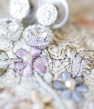 Halo-Set Diamond Earrings
Photography: lunaphoto
Read More:
http://www.insideweddings.com/weddings/organic-oceanside-wedding-in-malibu-california/350/ Dangling earring set on floral embroidery