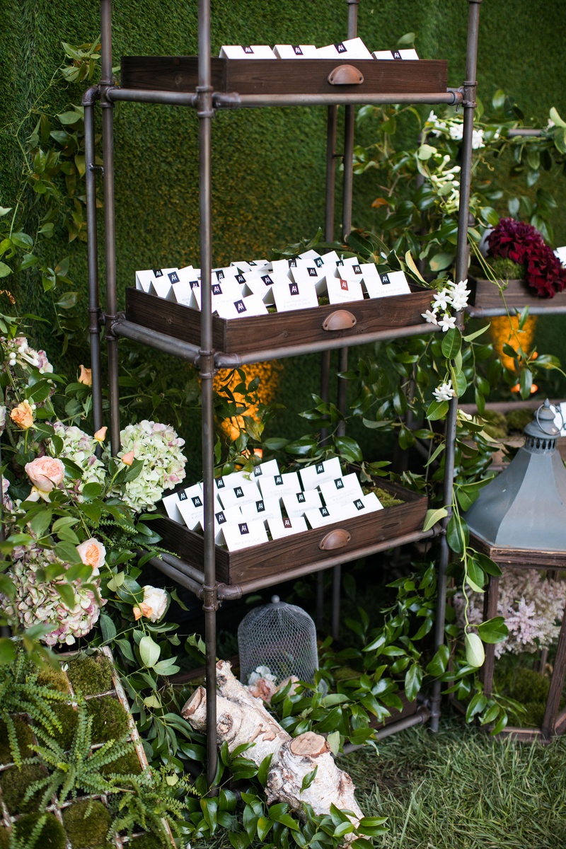 Escort Card Display on Shelving Unit
Photography: Samuel Lippke Studios
Read More:
http://www.insideweddings.com/weddings/tuscany-meets-rustic-california-outdoor-wedding-under-the-stars/1336/ wedding reception escort cards in wood tray on industrial book shelf hedge wall fall flowers green