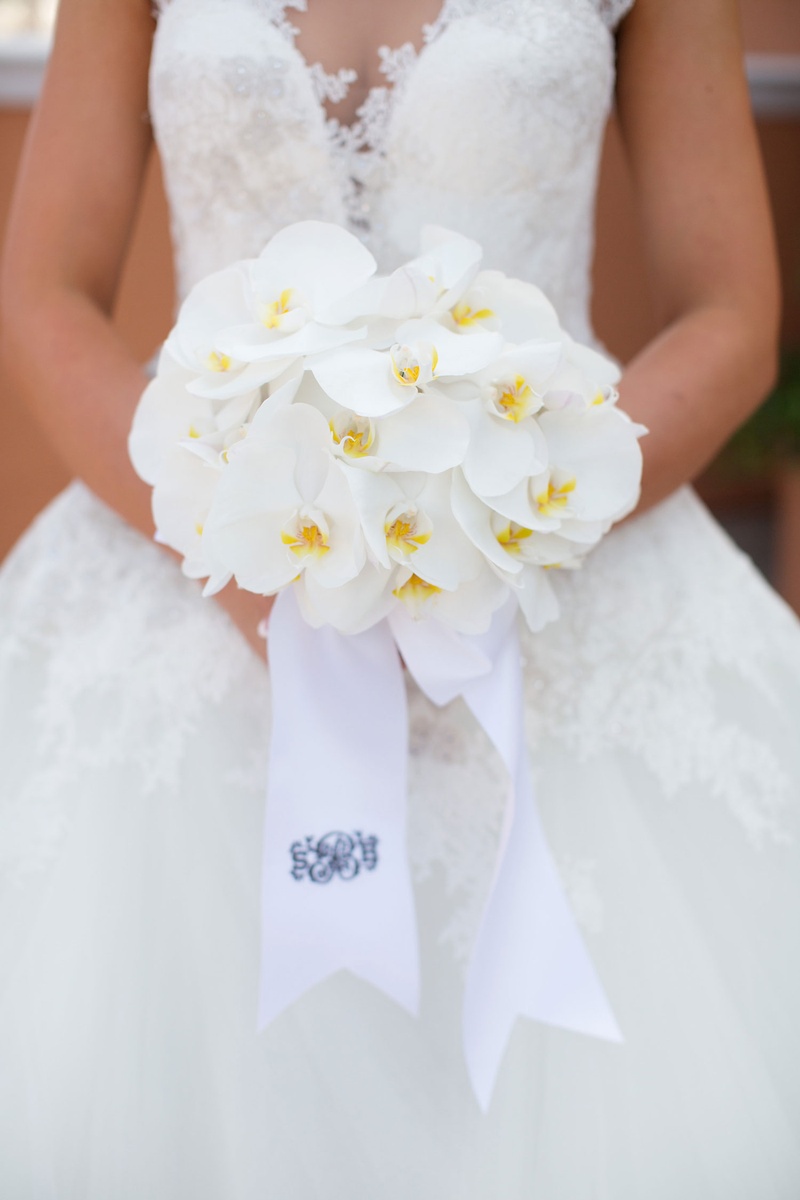 White Phalaenopsis Orchid Bouquet
Photography: Sarah Kate, Photographer
Read More:
http://www.insideweddings.com/weddings/outdoor-fall-ceremony-opulent-tented-reception-in-dallas-texas/1022/ Bride holding small bouquet of all white phalaenopsis orchid flowers and ribbon with monogram