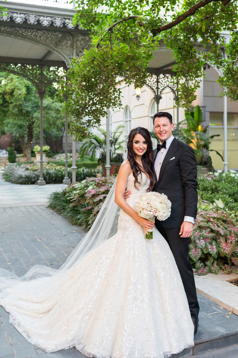 Newlyweds in Garden Courtyard
Photography: Perez Photography
Read More:
http://www.insideweddings.com/weddings/persian-american-ceremony-with-light-hued-reception-in-dallas/841/ bride in fit and flare trumpet gown groom in black tuxedo garden courtyard smiling