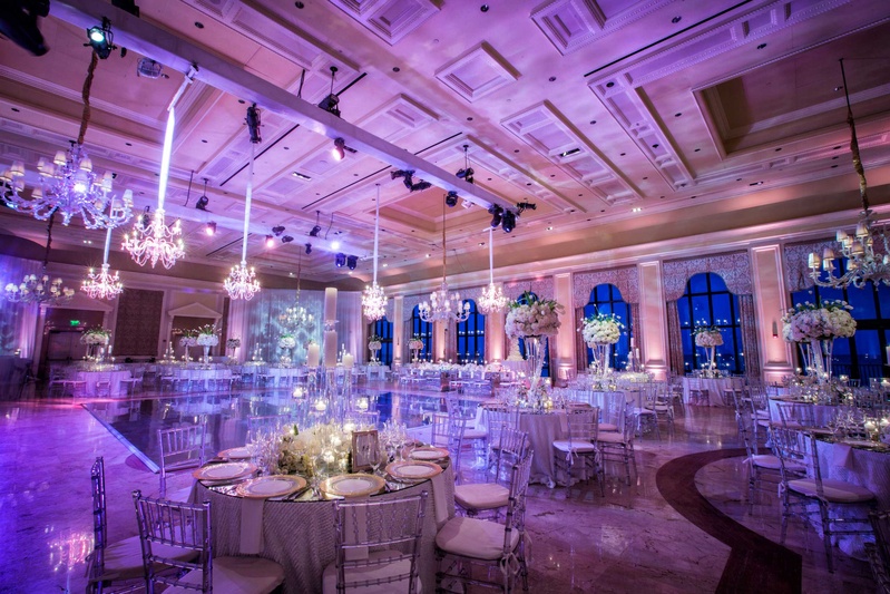 Violet Lighting in Grand Ballroom
Photography: Muñoz Photography
Read More:
http://www.insideweddings.com/weddings/colorful-jewish-ceremony-ballroom-reception-at-the-breakers/818/ Wedding reception at The Breakers with purple lighting, chandeliers, high and low centerpieces