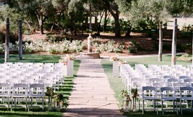 White Ceremony Chairs %26 Fountain
Photography: Lane Dittoe Photography
Read More:
http://www.insideweddings.com/weddings/romantic-garden-party-inspired-summer-wedding-at-a-country-club/967/ Outdoor wedding ceremony with stone aisle and white chairs lantern flowers alfresco grass lawn