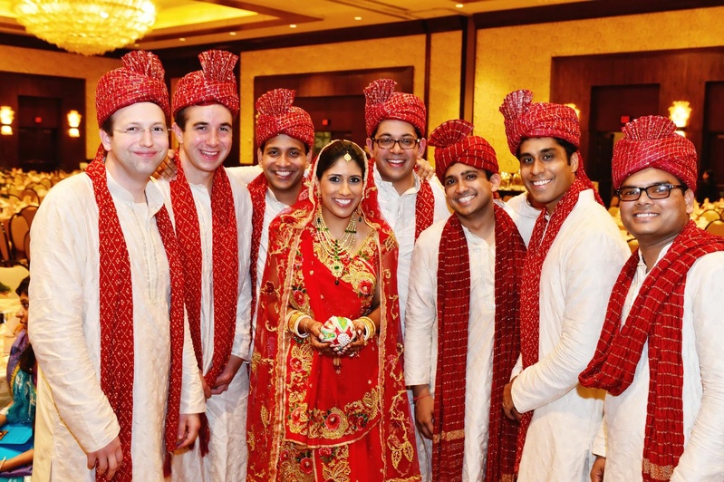 Bride With Groomsmen
Photography: Tomas Ramos Photographers
Read More:
http://www.insideweddings.com/weddings/houston-indian-wedding-celebration-with-800-person-guest-list/435/ Indian bride in a red lehenga and veil with gold and red embroidery with groomsmen in sherwanis