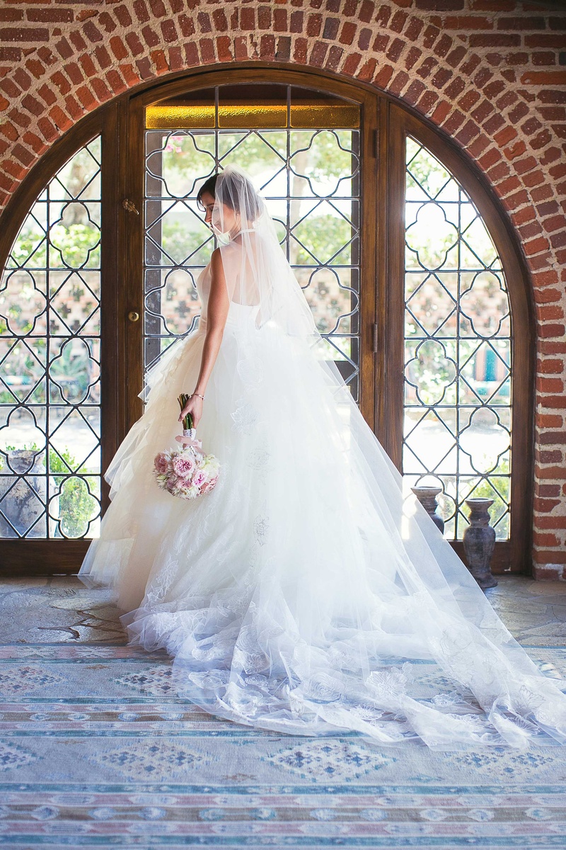 Bride Shows Off Back of Ball Gown
Photography: Callaway Gable
Read More:
http://www.insideweddings.com/weddings/alfresco-summer-wedding-with-lush-foliage-accents-in-california/805/ bride in white tulle ball gown with plunging halter neckline posing to show off back of dress veil