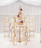 Gold Cake %26 Dessert Display
Photography: Milanés Photography
Read More:
http://www.insideweddings.com/weddings/glamorous-white-gold-wedding-at-a-private-estate-in-georgia/1060/ Wedding cake on gold riser with gold bookshelves featuring other desserts surrounding it orchids