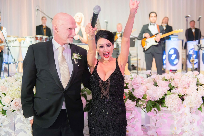 Third Dress for Vow Renewal
Photography: The Yodsukars
Read More:
http://www.insideweddings.com/weddings/glam-10th-wedding-anniversary-party-vow-renewal-in-california/917/ Bride in black beaded designer gown with microphone at wedding reception live band