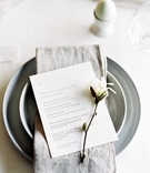 Menu with Sprig of Magnolia
Photography: O’Malley Photographers
Read More:
http://www.insideweddings.com/weddings/a-sweet-springtime-tablescape-with-a-soft-neutral-color-palette/1059/ grey charger plate, grey napkin, dinner menu with sprig of magnolia, bridal shower