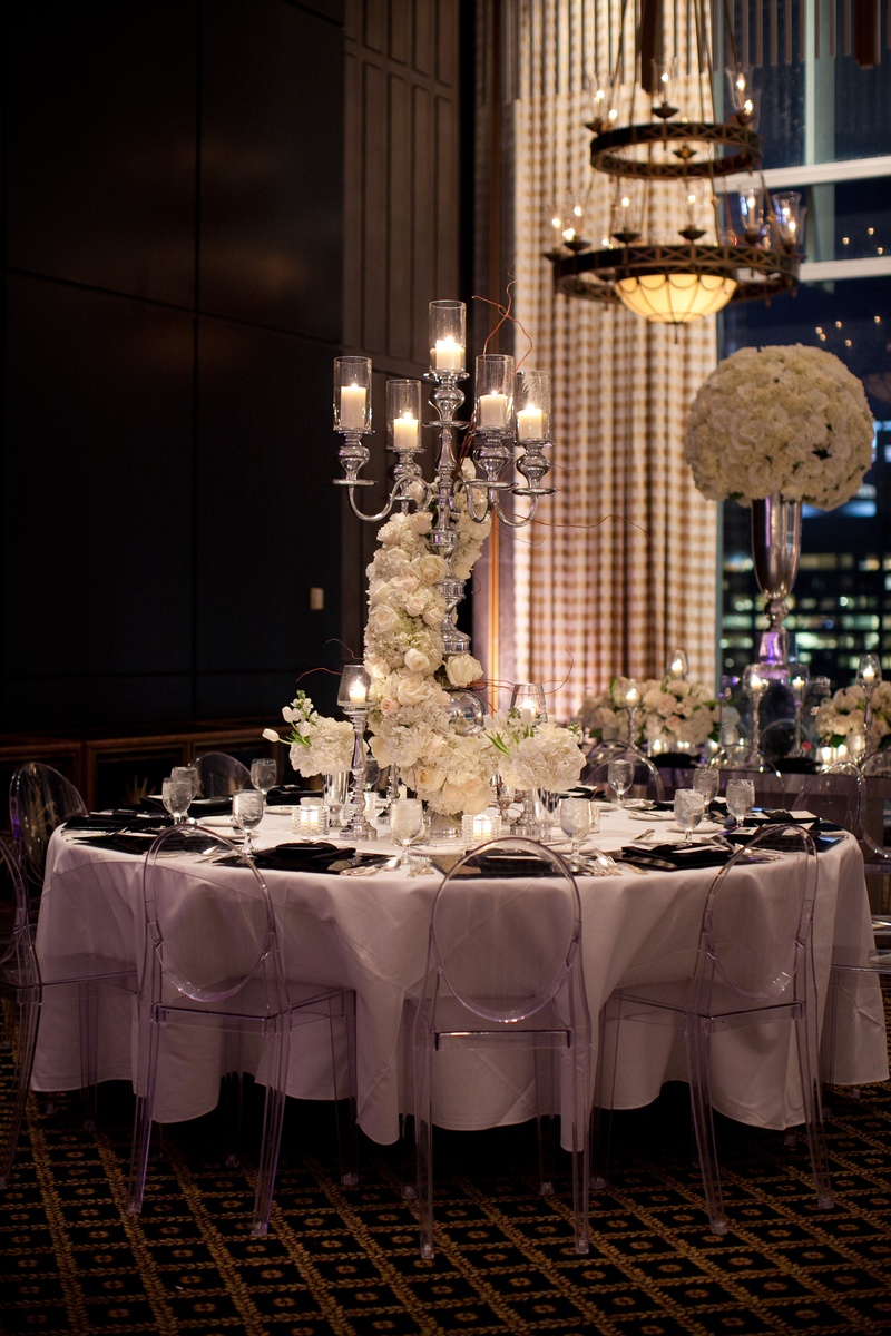 Silver Candelabra Centerpiece
Photography: Collins Metu Photography
Read More:
http://www.insideweddings.com/weddings/sarita-minor-and-jarett-dillard/432/ Ghost chairs around reception table with silver candlestick