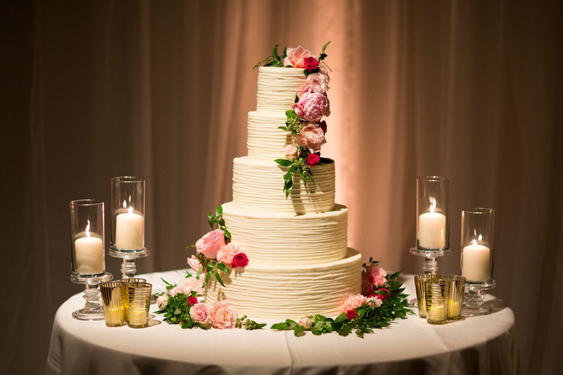 Classic Five Layer Wedding Cake
Photography: Jay Lawrence Goldman Photography
Read More:
http://www.insideweddings.com/weddings/outdoor-ceremony-ballroom-reception-with-pink-flowers-greenery/1135/ Wedding cake with five ivory layer tier with candles pink flowers green leaves greenery