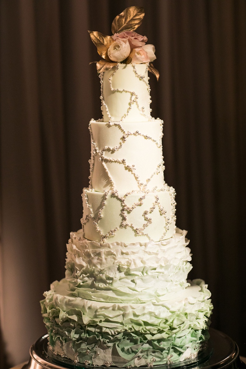 Five-Layer Cake with Gold Leaf Topper
Photography: Samuel Lippke Studios
Read More:
http://www.insideweddings.com/weddings/glamorous-alfresco-ceremony-ballroom-reception-and-after-party/1041/ Five layer wedding cake two ruffle layers at bottom and pearl beaded design on top three tiers fresh