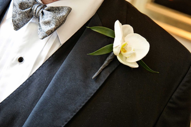 Groom's Single White Orchid Boutonniere
Photography: KingenSmith
Read More:
http://www.insideweddings.com/weddings/delicately-detailed-chicago-wedding-with-jewish-christian-customs/762/ groom with white orchid boutonniere on a black suit jacket tux and gray detailed tie