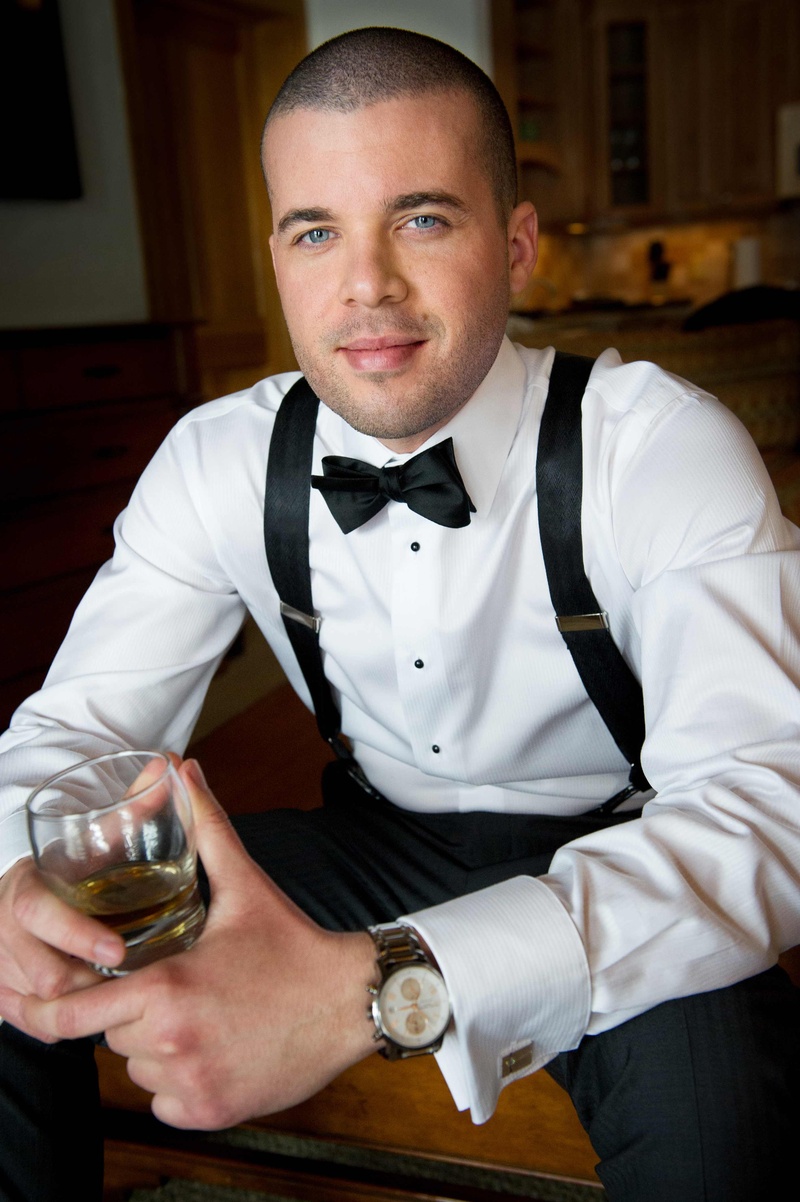 Groom in Suite
Photography: Handeland Tesoro Photography
Read More:
http://www.insideweddings.com/weddings/snowy-outdoor-winter-ceremony-cozy-lodge-reception/522/ Man in suspenders and bow tie drinking whiskey