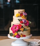 Semi-Naked Cake with Fresh Flowers
Photography: Kent Drake Photography
Read More:
http://www.insideweddings.com/weddings/bright-and-colorful-wedding-palette-with-ceremony-overlooking-lake/1315/ semi-naked, lightly frosted, small four-tiered cake with bright pink, yellow, and lavender flowers