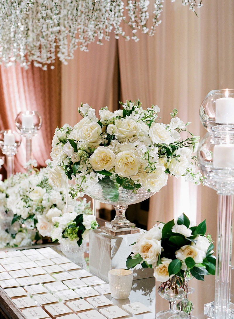Ivory %26 Greenery Escort Card Table Décor
Photography: Jose Villa Photography
Read More:
http://www.insideweddings.com/weddings/glamorous-sophisticated-garden-themed-ballroom-wedding-in-chicago/905/ Escort cards on mirror table with clear vases filled with garden roses and other white flowers