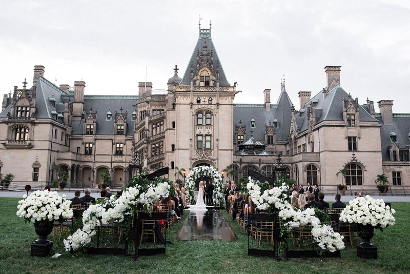 Ceremony on Biltmore Estate Lawn
Photography: Parker J Pfister Photographer
Read More:
http://www.insideweddings.com/weddings/gorgeous-alfresco-ceremony-tented-reception-at-a-luxurious-estate/1044/ Wedding ceremony with black wrought iron gates, white flowers, black aisle runner outdoors castle