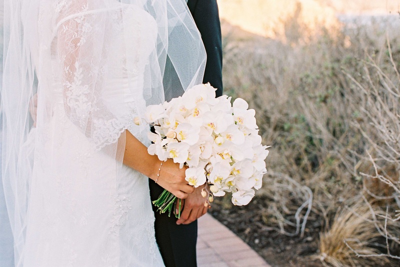 Lace Dress %26 White Orchid Bouquet
Photography: Braedon Photography
Read More:
http://www.insideweddings.com/weddings/orthodox-jewish-wedding-with-outdoor-ceremony-inspired-by-the-sea/812/ Bride in lace Alfred Angelo wedding dress holding white phalenopsis orchid bouquet delicate bracelet