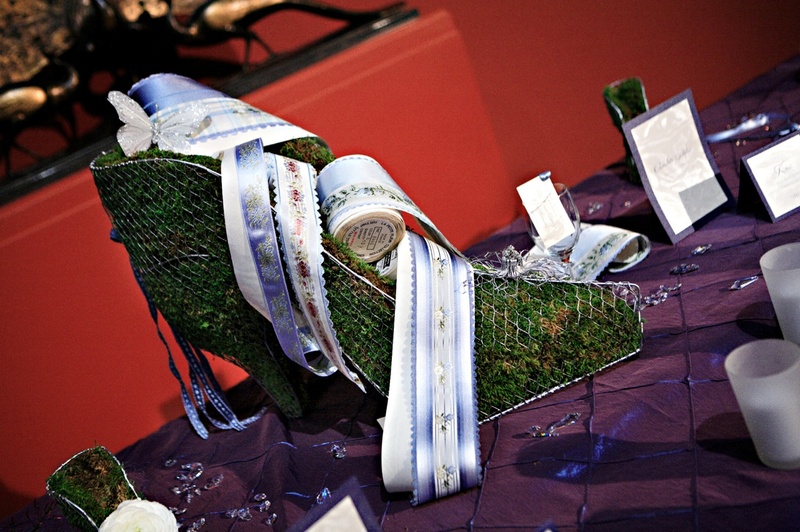 Reception Decor
Photography: Marie Labbancz Photography
Read More:
http://www.insideweddings.com/weddings/elegant-spring-wedding-at-the-pennsylvania-academy-of-the-fine-arts/176/ Metal shoe mold filled with grass and decorated with floral ribbons and butterfly appliqué