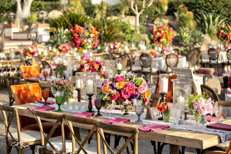 Wood Long Table with Colorful Centerpieces
Photography: Laurie Bailey Photography
Read More:
http://www.insideweddings.com/weddings/outdoor-jewish-ceremony-reception-with-colorful-bohemian-decor/1330/ wedding reception wood table vineyard chair orange head table pink yellow purple flowers