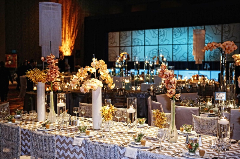 Floral Décor
Photography: Tomas Ramos Photographers
Read More:
http://www.insideweddings.com/weddings/houston-indian-wedding-celebration-with-800-person-guest-list/435/ Wedding reception table lined with tall and low clear and milky vases with orchids