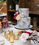 Concrete-Inspired Bridal Shower Cake
Photography: Jessica Claire Photography
Read More:
http://www.insideweddings.com/weddings/unique-chic-bridal-shower-with-dark-and-moody-color-scheme/1335/ small two-tier grey marble cake made to look like concrete with gold foil and fresh flowers