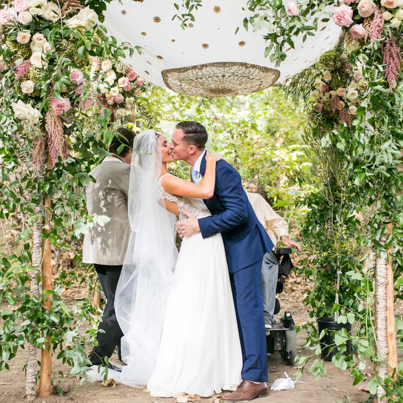 Bride %26 Groom Kiss Under Outdoor Chuppah
Photography: Samuel Lippke Studios
Read More:
http://www.insideweddings.com/weddings/a-rustic-camp-themed-outdoor-wedding/908/ Bride in Maradee Wahl veil and groom in navy blue tie kiss under pretty garden chuppah outside pink