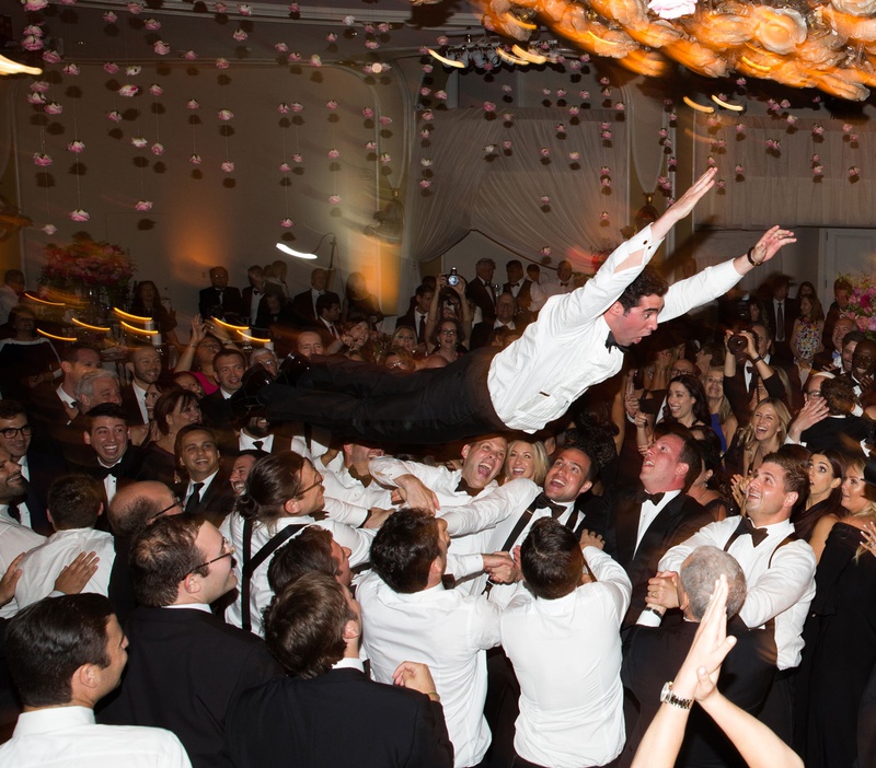 Groom Crowdsurfing at Reception
Photography: Jay Lawrence Goldman Photography
Read More:
http://www.insideweddings.com/weddings/outdoor-ceremony-ballroom-reception-with-pink-flowers-greenery/1135/ Groom without tuxedo jacket body surfing crowd surfing at wedding reception during hora jewish