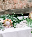 King Protea Blooms and Greenery
Photography: Kaylie Plummer Photography
Read More:
http://www.insideweddings.com/weddings/chic-alfresco-hotel-wedding-with-elements-of-modern-greenery/1350/ wedding reception with italian rusus, eucalyptus, and king protea blooms