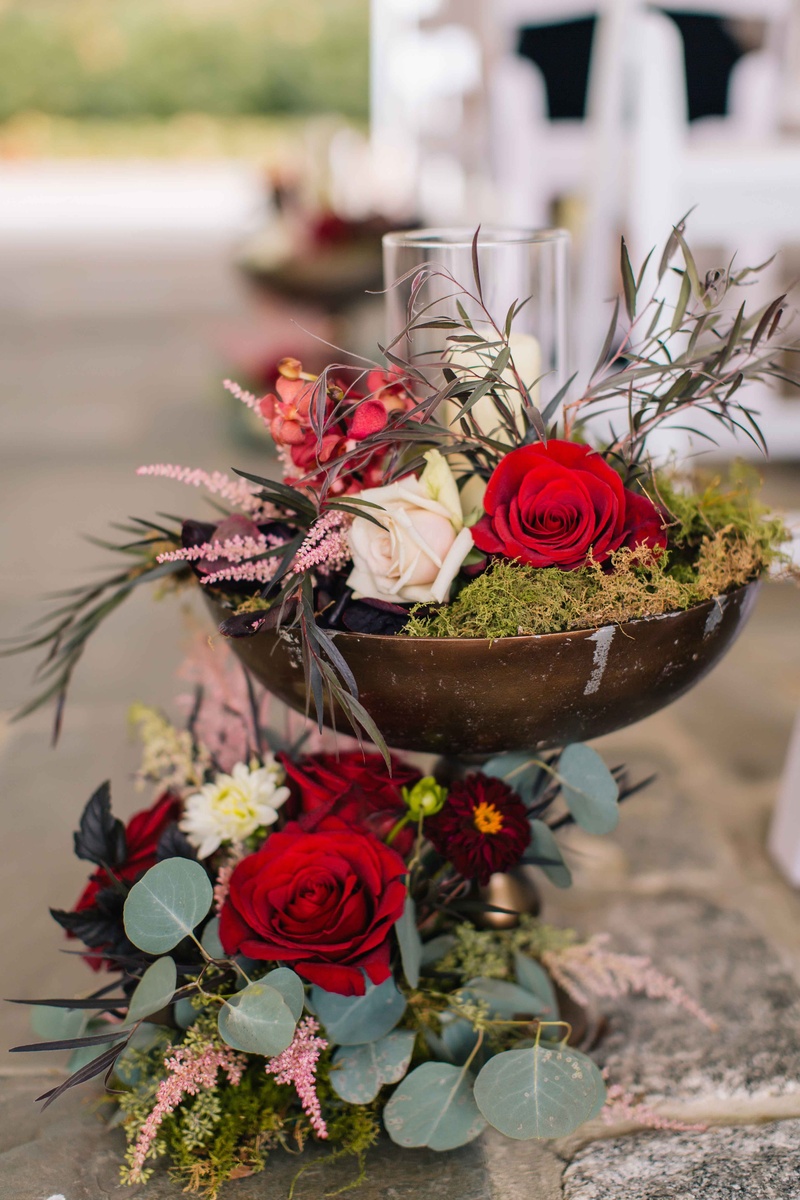 Wine-Colored Florals and Rustic Décor
Photography: Vue Photography
Read More:
http://www.insideweddings.com/weddings/baroque-autumn-wedding-with-deep-wine-tones-in-north-carolina/770/ wine-colored flowers and green moss inside a rustic brown vase with sage and olive greenery candles