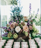 Floral Escort Cards
Photography: Justin Johnson Photography
Read More:
http://www.insideweddings.com/weddings/metallic-dusty-purple-color-palette-at-venue-with-stunning-views/1305/ rows of escort cards with floral borders in front of colorful flower arrangement