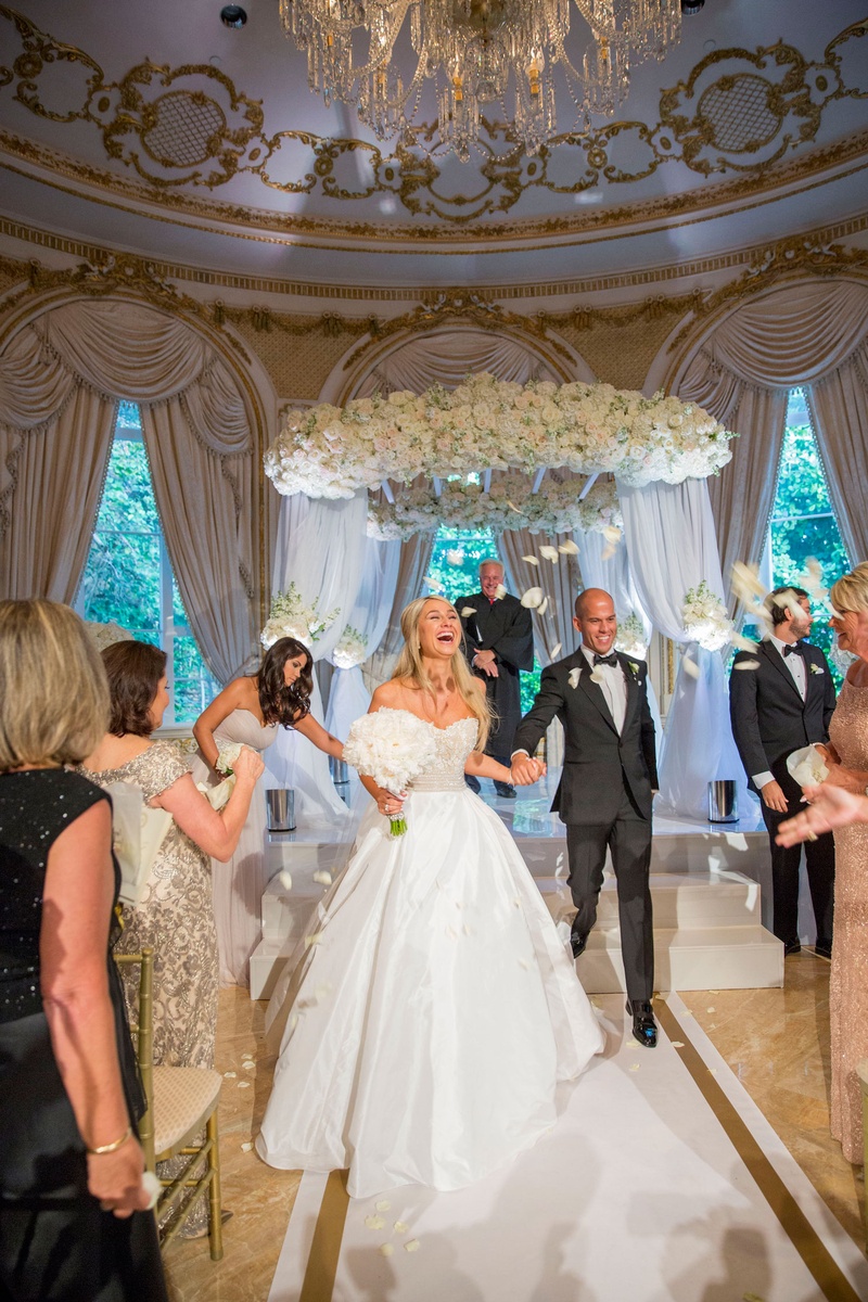 Bride %26 Groom's Reaction After Saying "I Do"
Photography: Nancy Cohn Photography
Read More:
http://www.insideweddings.com/weddings/destination-wedding-with-white-gold-color-palette-in-palm-beach/1028/ Bride in strapless Reem Acra wedding dress and groom holding hands walking on white gold aisle