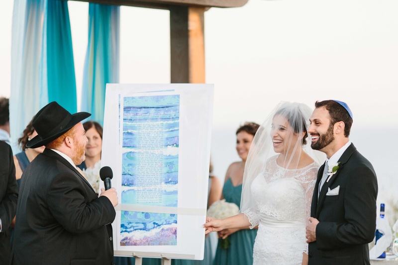 Bride %26 Groom with Orthodox Rabbi
Photography: Braedon Photography
Read More:
http://www.insideweddings.com/weddings/orthodox-jewish-wedding-with-outdoor-ceremony-inspired-by-the-sea/812/ bride and groom smile at oceanfront ceremony with watercolor ketubah displayed at wedding
