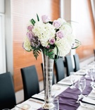 Tall Vase with White %26 Purple Flowers
Photography: Sterling Imageworks
Read More:
http://www.insideweddings.com/weddings/sophisticated-soiree-at-a-presidential-library-in-little-rock/1033/ Long rectangle wedding table with purple runner silver vase white hydrangea purple rose and greenery